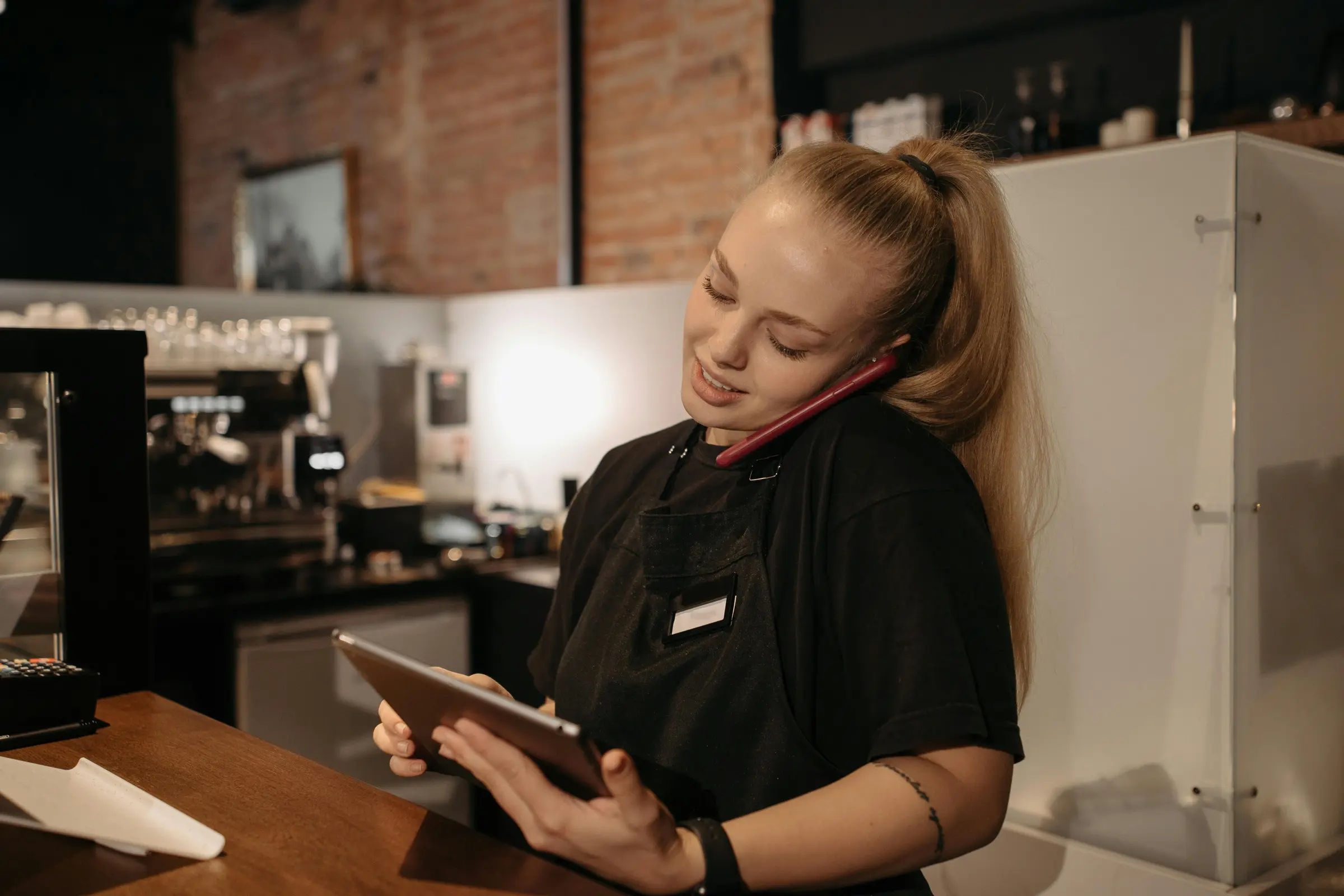 Front-of-house staff member handling a guest phone call while managing reservations